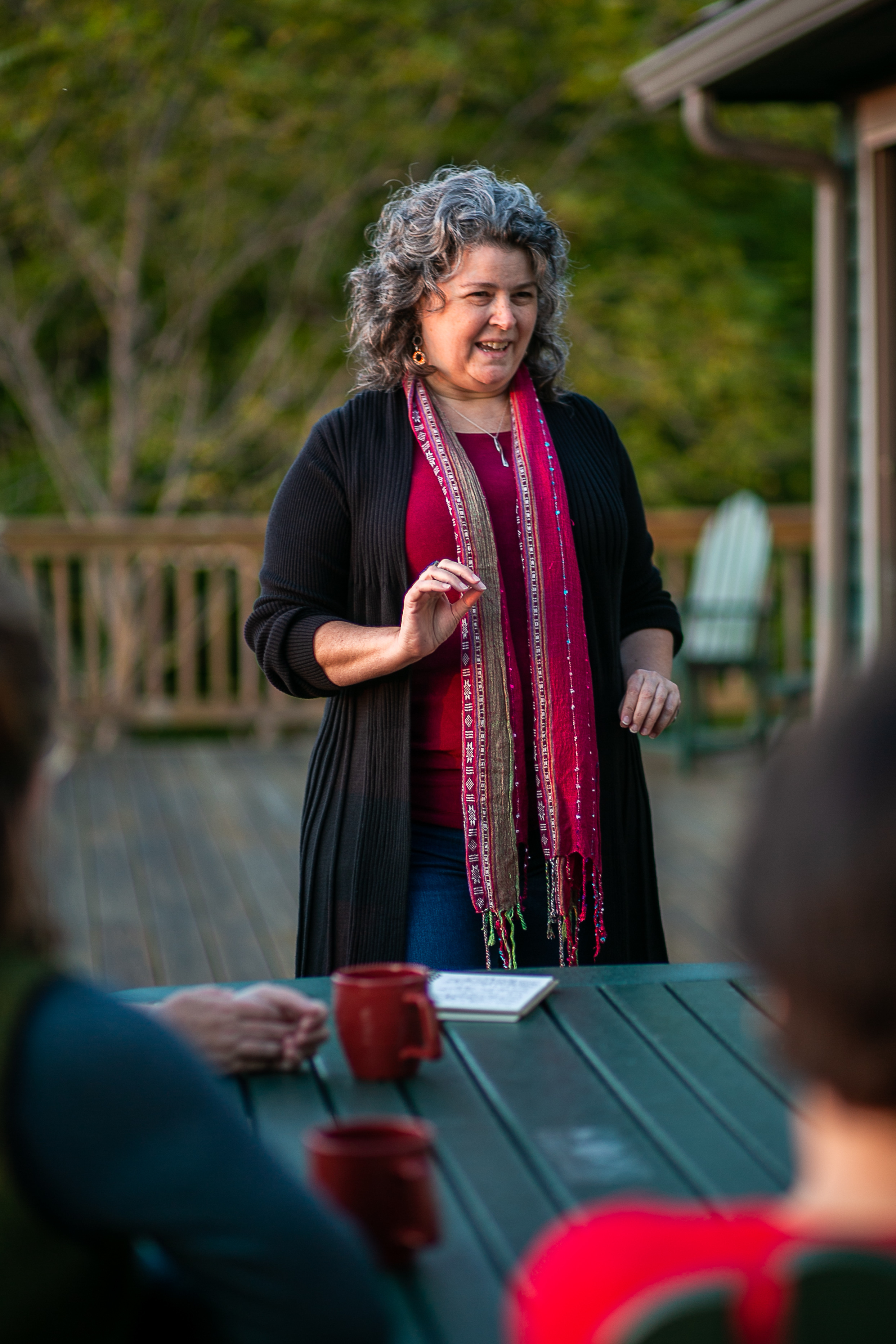 Cat Lazaroff, consultant and facilitator, leads a group discussion in a relaxed outdoor setting.